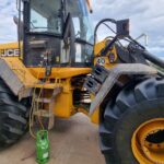 Traktor mit angeschlossenem Service Manometer einer Fachfirma die gerade die Klimaanlage des Fahrzeuges repariert und Kältemittel nachfüllt.