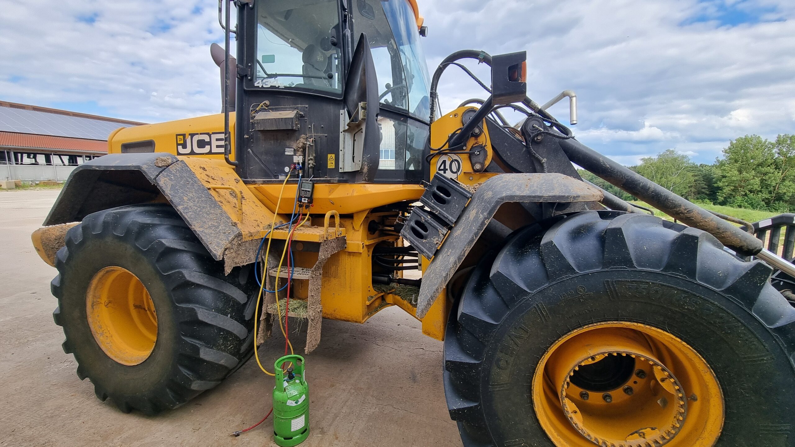 Traktor mit angeschlossenem Service Manometer einer Fachfirma die gerade die Klimaanlage des Fahrzeuges repariert und Kältemittel nachfüllt.
